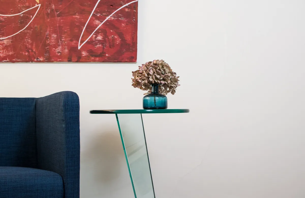Sessel, Glastisch und Wandbild im Therapieraum